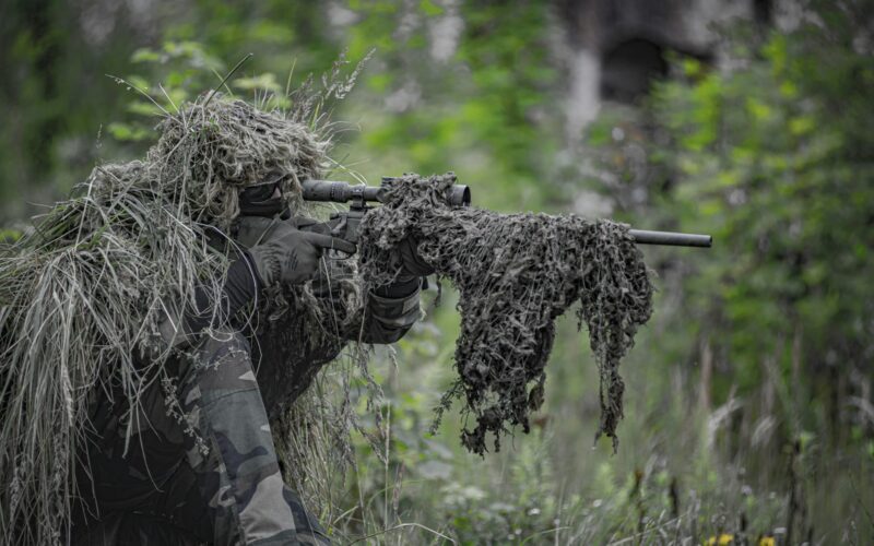 sniper wearing a ghillie in selective focus photography